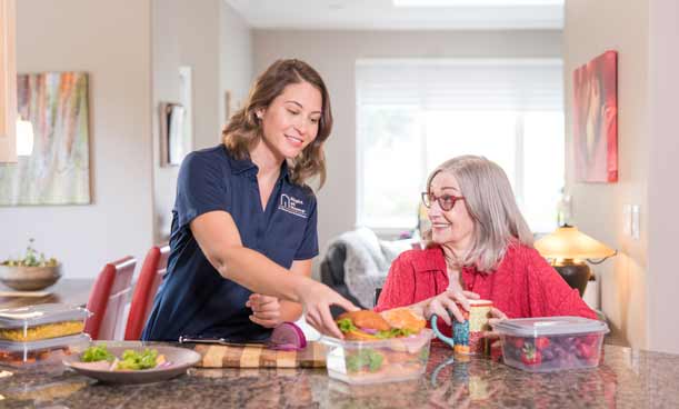 MealPeparation-Client-Caregiver-Personal Female caregiver helping a female client prepare her meals for the week.
